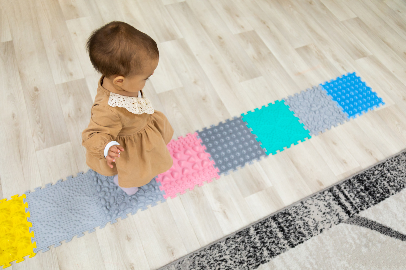 Toddler walking on orthopedic sensory mats