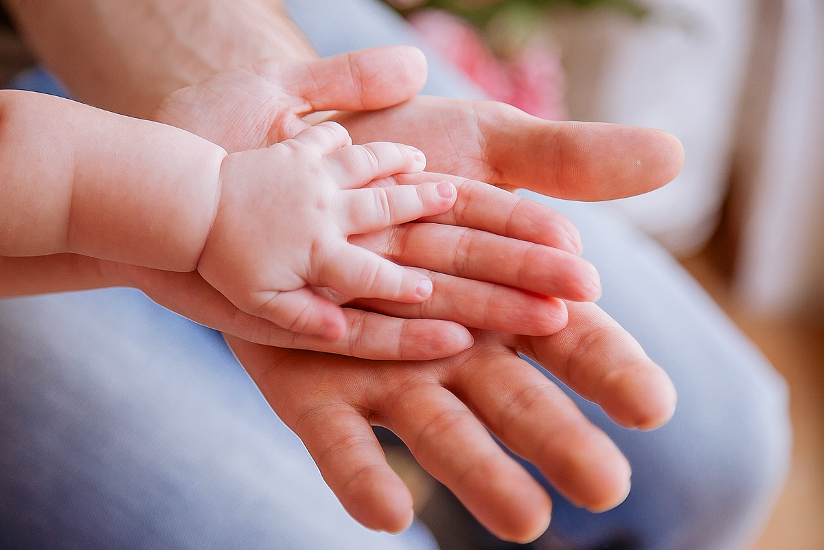 Hand of baby and parents