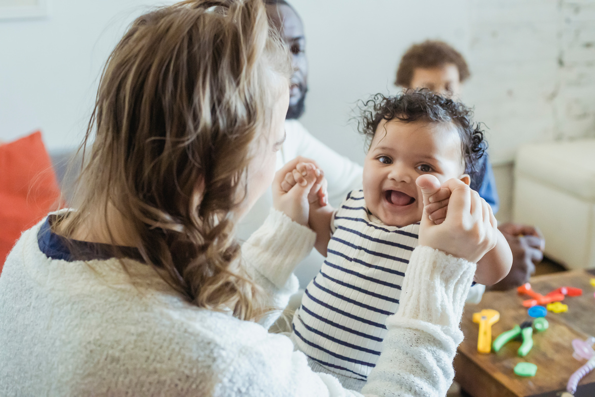 Mother playing with cute black baby